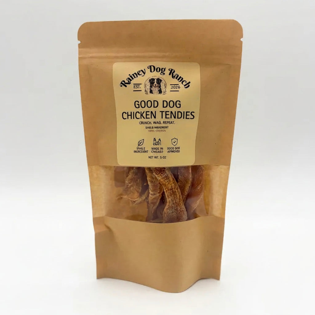 A stand-up kraft paper pouch of Rainey Dog Ranch Good Dog Chicken Tendies, with a clear window showing the dried chicken tendies inside, set against a plain white background.