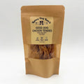 A stand-up kraft paper pouch of Rainey Dog Ranch Good Dog Chicken Tendies, with a clear window showing the dried chicken tendies inside, set against a plain white background.