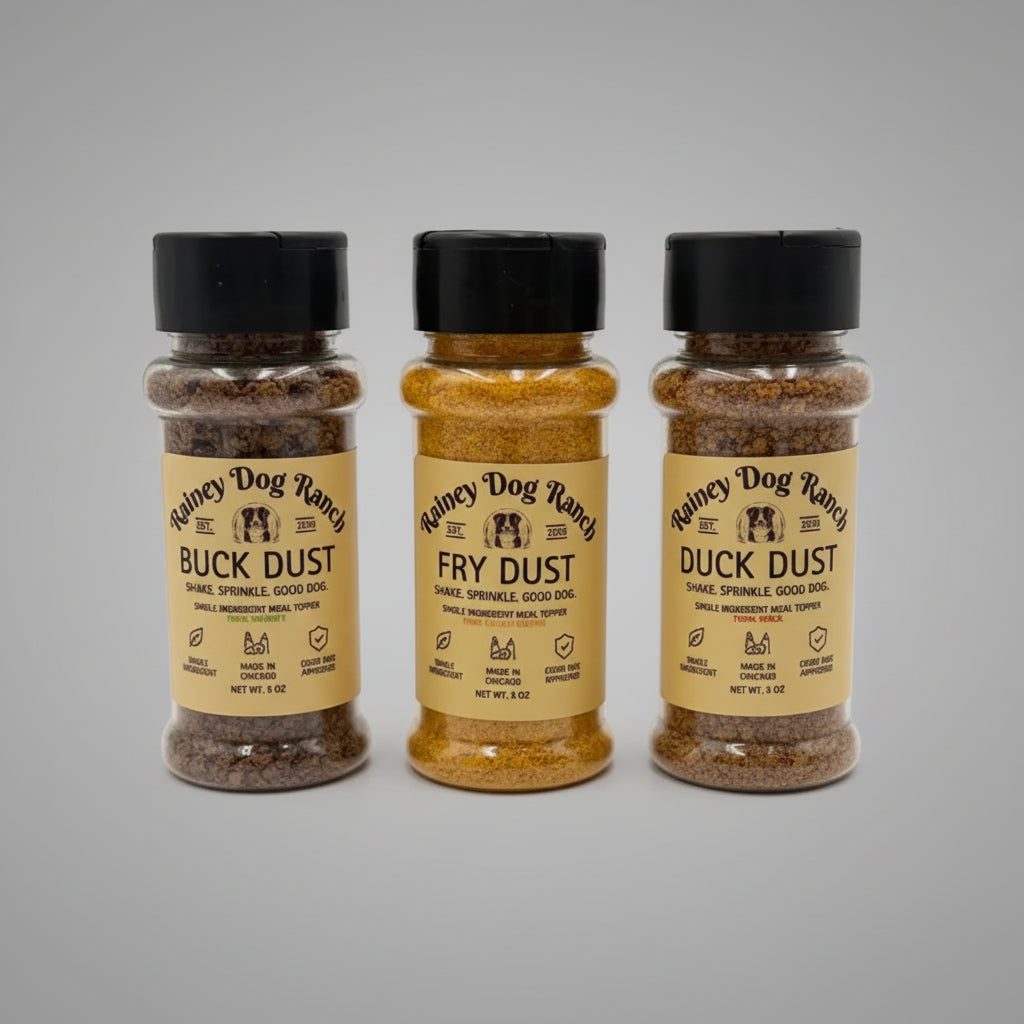 Three spice seasoning bottles labeled 'Rainey Dog Ranch' on a light gray background: Buck Dust, Fry Dust, and Duck Dust.