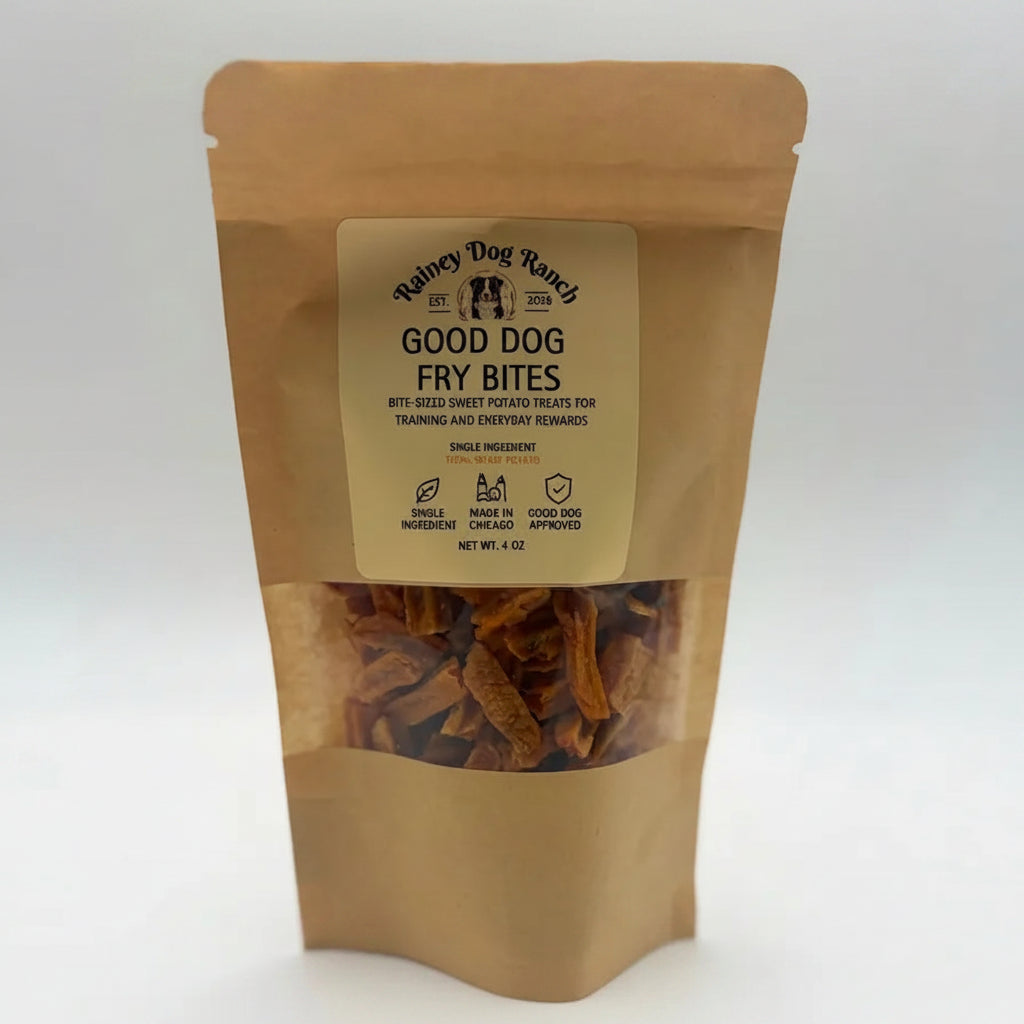 A stand-up kraft paper pouch of Rainey Dog Ranch Good Dog Fry Bites, featuring a clear window showing the brown fried dog treats inside, set against a plain white background.