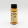 A bottle of Rainey Dog Ranch Fry Dust seasoning with a black cap and beige label, filled with a golden-brown spice blend, set against a clean white background.